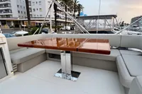 Luxurious seating area on 2017 Cranchi E 52 F yacht with polished wooden table.