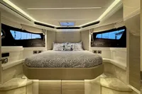 Luxurious bedroom interior of 2017 Cranchi E 52 F yacht with elegant bedding and ambient lighting.