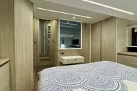 Luxurious 2017 Cranchi E 52 F yacht bedroom with modern decor and elegant bedding.