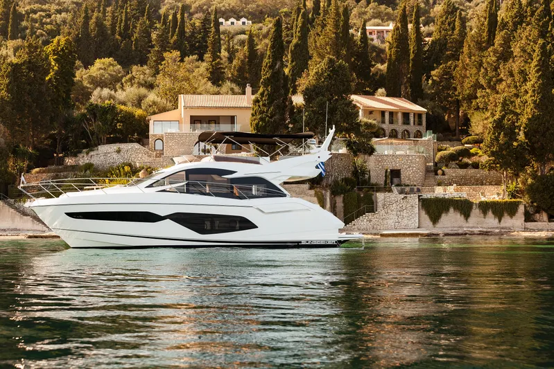 M/y Lady K Yacht Photos Pics 2018 Sunseeker Manhattan 52 yacht cruising near a scenic coastal villa.