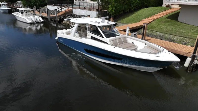  Yacht Photos Pics 2020 Boston Whaler 420 Outrage boat docked in a serene canal.