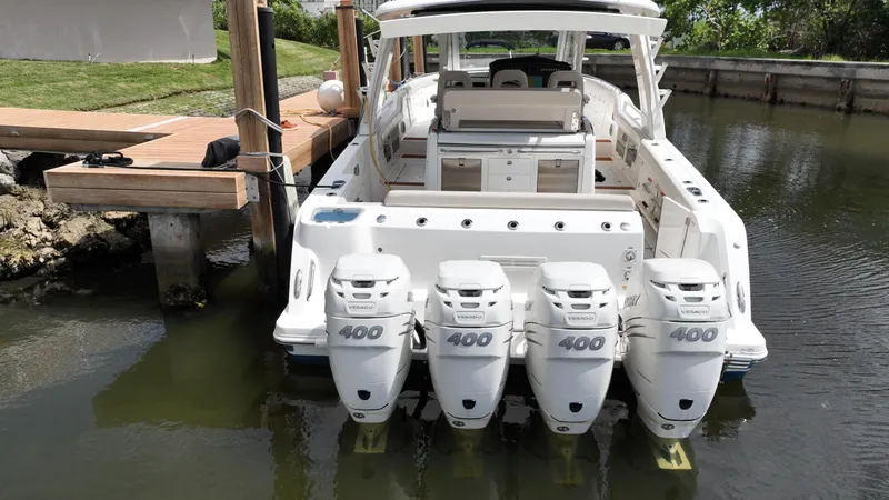  Yacht Photos Pics 2020 Boston Whaler 420 Outrage with four powerful outboard engines docked in calm water.