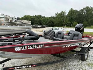 2022 Tracker Pro Team 175 TXW boat in a parking lot, featuring a red exterior and Mercury engine.