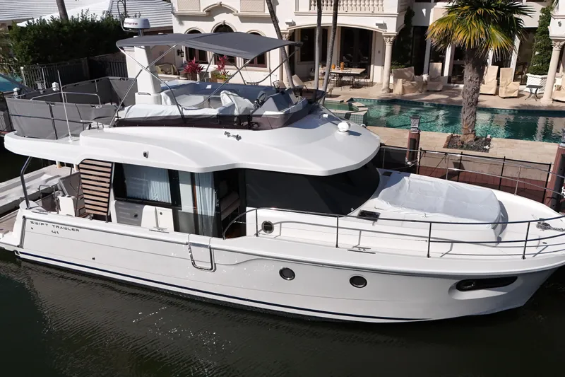 Carolina Blues Yacht Photos Pics 2025 Beneteau Swift Trawler 41 Fly docked near luxury waterfront property.