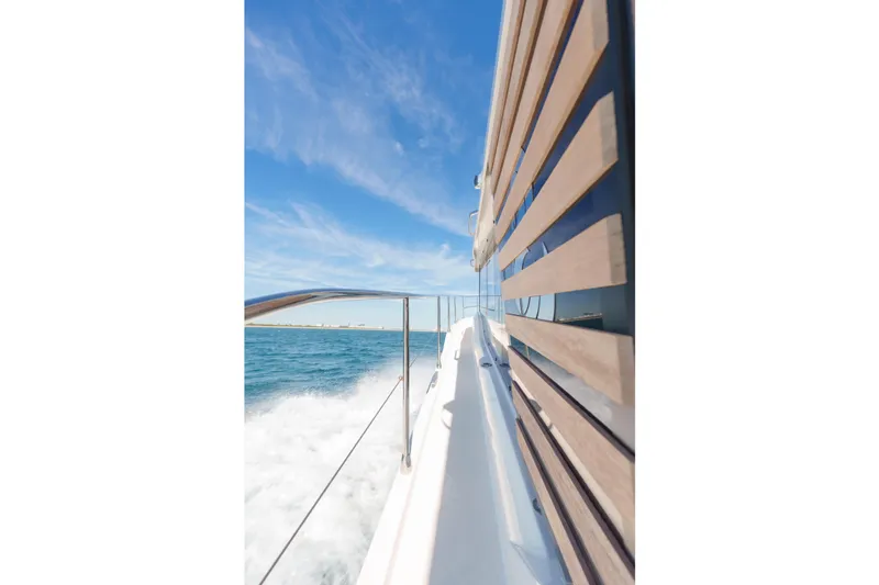 Carolina Blues Yacht Photos Pics 2025 Beneteau Swift Trawler 41 Fly cruising on open water under clear blue sky.