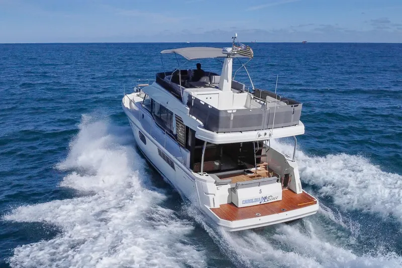Carolina Blues Yacht Photos Pics 2025 Beneteau Swift Trawler 41 Fly cruising on open sea, rear view.