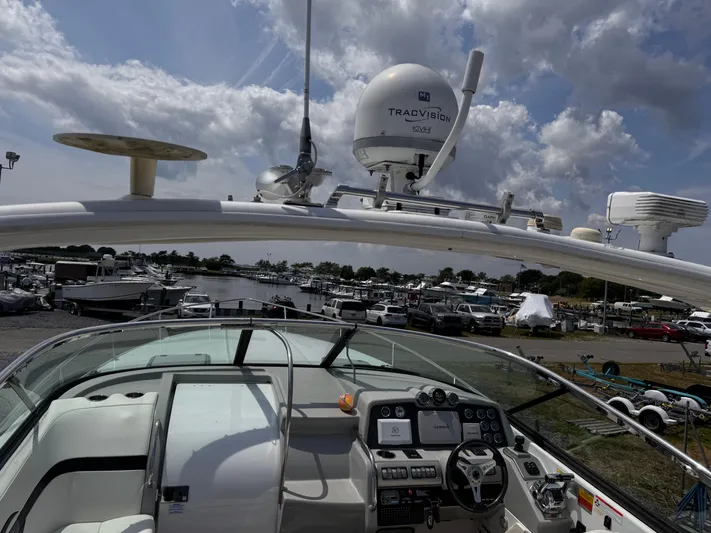  Yacht Photos Pics 2009 Formula 350ss boat dashboard with advanced navigation equipment, docked at a marina under cloudy skies.