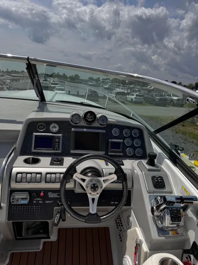  Yacht Photos Pics 2009 Formula 350ss boat dashboard with steering wheel and control panel under cloudy sky.