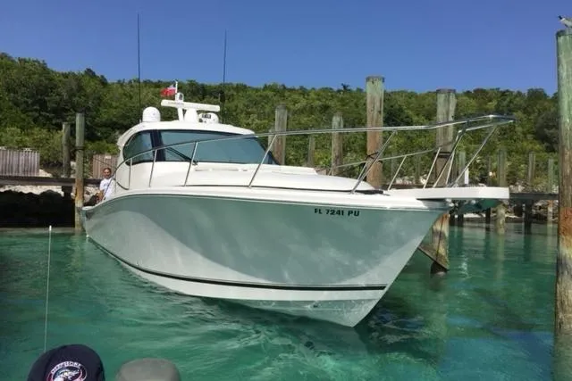  Yacht Photos Pics 2015 Jupiter 41 SB boat docked in clear turquoise water, surrounded by lush greenery.