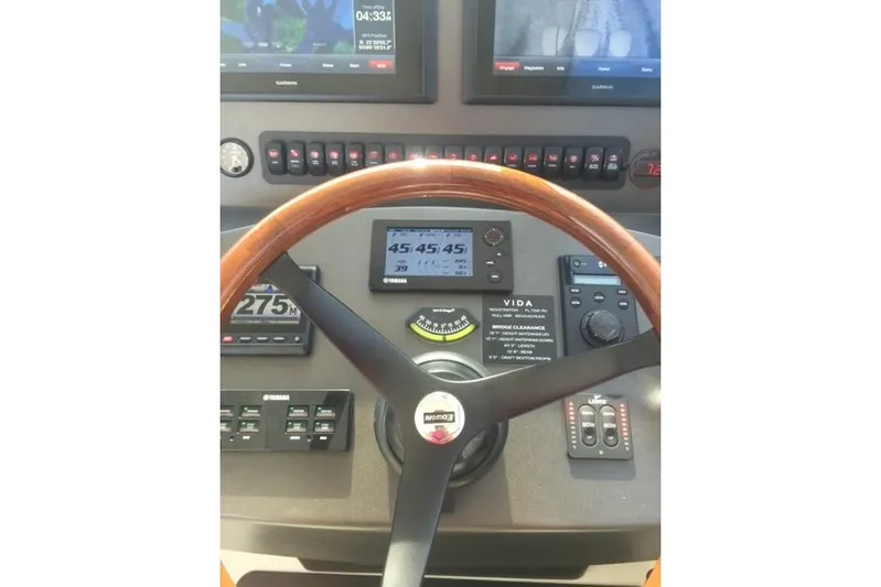  Yacht Photos Pics Helm of 2015 Jupiter 41 SB boat with navigation instruments and wooden steering wheel.