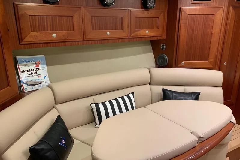  Yacht Photos Pics Luxurious interior of 2015 Jupiter 41 SB yacht with beige seating and navigation book.