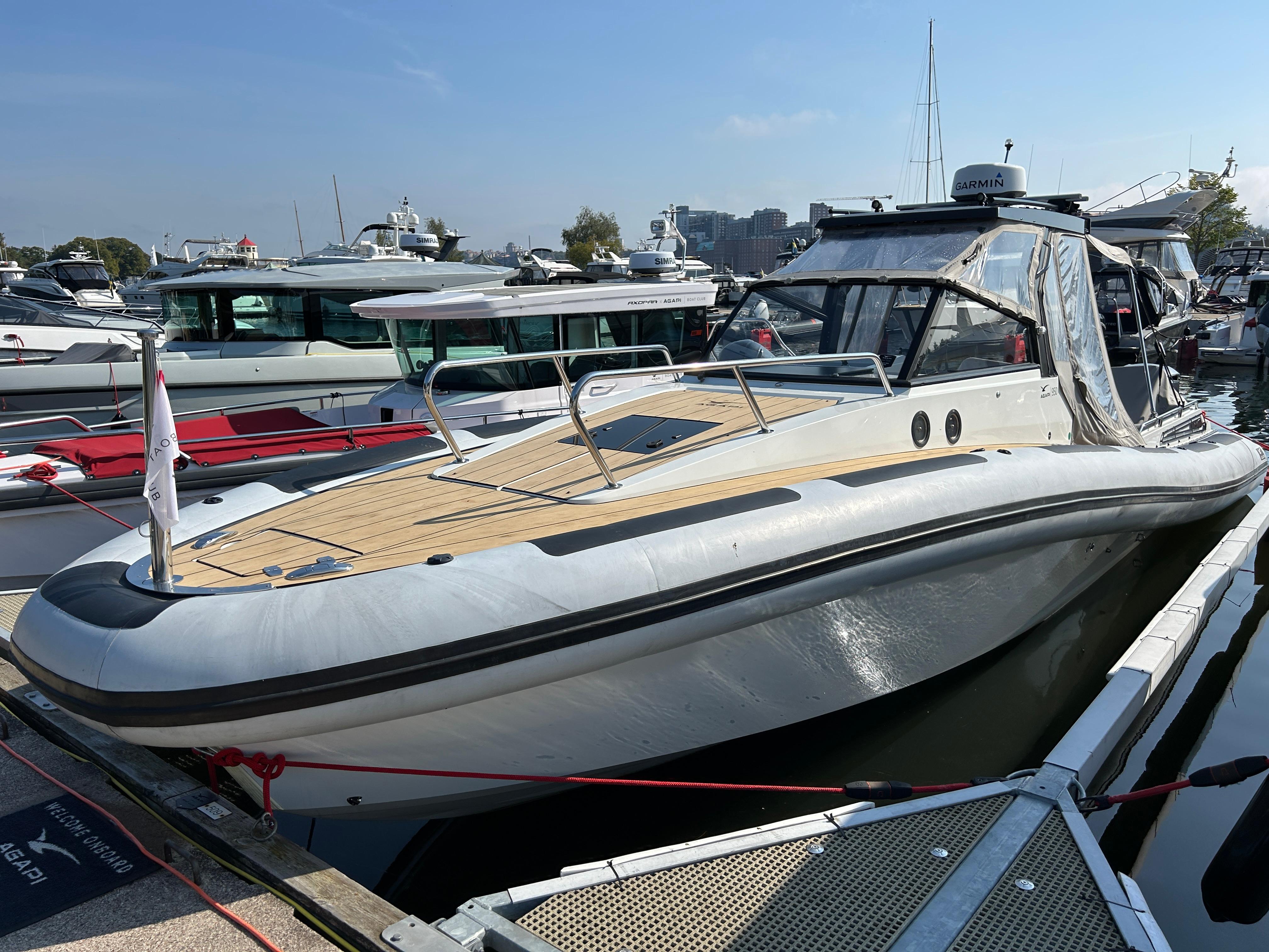 2019 Agapi 950 boat docked at marina under clear blue sky.