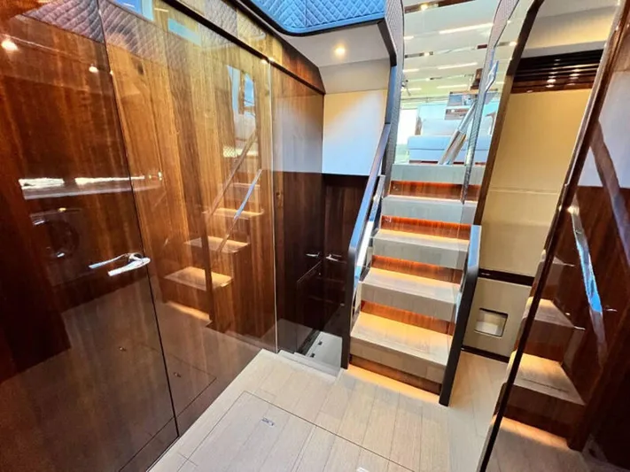 Blind Date Yacht Photos Pics Luxurious interior of 2020 Fairline Squadron 68 yacht with polished wood and modern staircase.