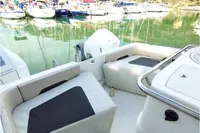 2023 Aquila 28 Molokai boat interior with seating, docked in a scenic marina.