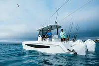 2023 Aquila 28 Molokai boat with anglers, equipped for fishing, on open water.