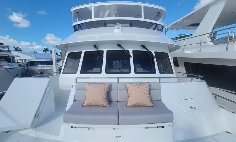 Our Way III Yacht Photos Pics 2023 Outer Reef Yachts 720 Motoryacht with cushioned seating on deck under a clear blue sky.
