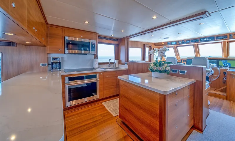 Our Way III Yacht Photos Pics Luxurious kitchen interior of 2023 Outer Reef Yachts 720 Motoryacht with modern appliances and wood finish.