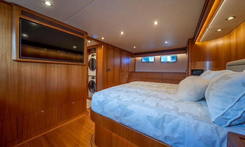 Our Way III Yacht Photos Pics Luxurious bedroom in 2023 Outer Reef Yachts 720 Motoryacht with wood paneling and modern amenities.