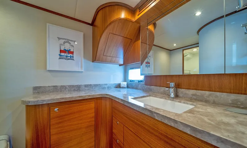 Our Way III Yacht Photos Pics Luxurious bathroom in 2023 Outer Reef Yachts 720 Motoryacht with wood cabinetry and modern fixtures.