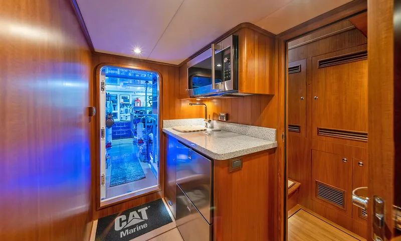 Our Way III Yacht Photos Pics 2023 Outer Reef Yachts 720 Motoryacht interior with modern kitchenette and wooden cabinetry.