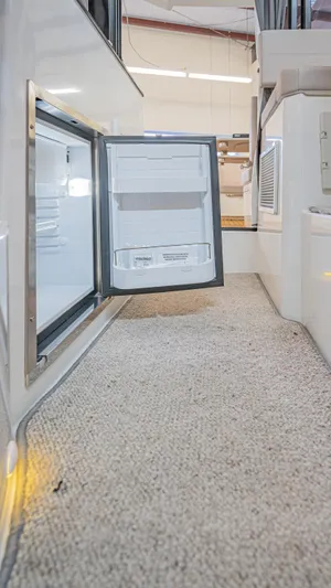  Yacht Photos Pics 2024 Skamander 920 Explorer MAX interior with open mini fridge on carpeted floor.