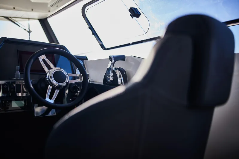  Yacht Photos Pics Interior of 2024 Skamander 920 Explorer MAX boat, featuring steering wheel and controls.