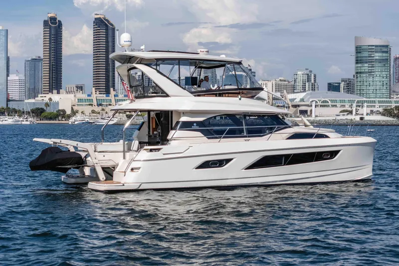 Catatude Yacht Photos Pics 2016 Aquila 44 Power Cat yacht cruising near city skyline.