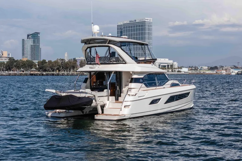 Catatude Yacht Photos Pics 2016 Aquila 44 Power Cat yacht on water with city skyline backdrop.