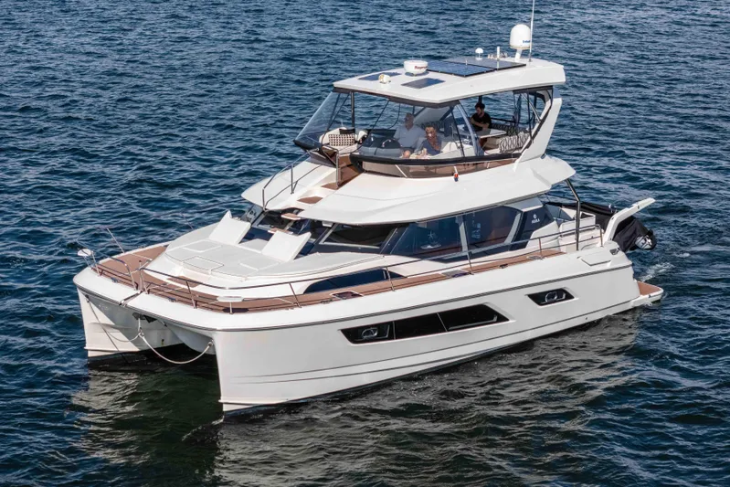 Catatude Yacht Photos Pics 2016 Aquila 44 Power Cat cruising on open water, showcasing sleek design and spacious deck.