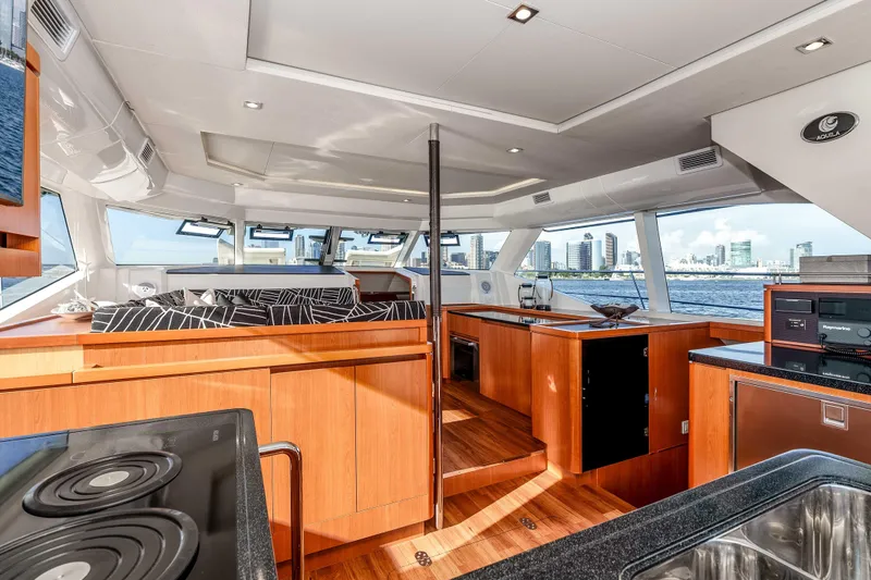 Catatude Yacht Photos Pics Luxurious interior of 2016 Aquila 44 Power Cat with modern kitchen and city skyline view.