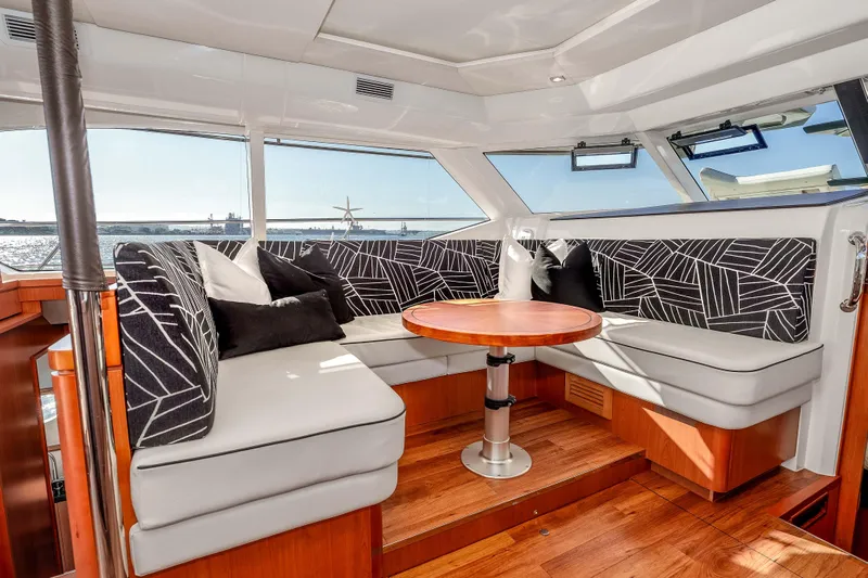 Catatude Yacht Photos Pics Luxurious interior of 2016 Aquila 44 Power Cat with stylish seating and wooden table.