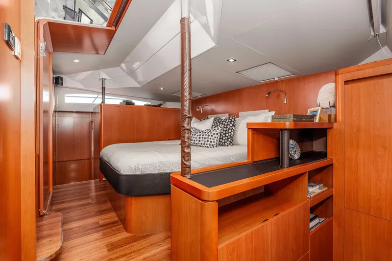 Catatude Yacht Photos Pics Luxurious interior of 2016 Aquila 44 Power Cat with wooden furnishings and cozy bedding.