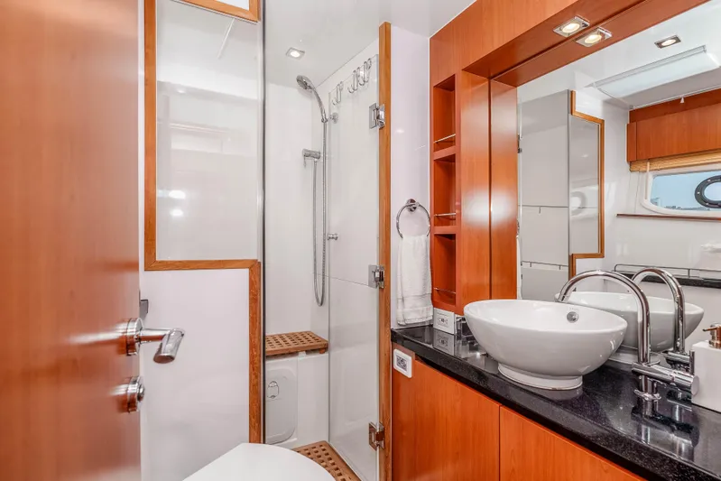 Catatude Yacht Photos Pics Luxurious bathroom on 2016 Aquila 44 Power Cat with modern fixtures and elegant wood accents.