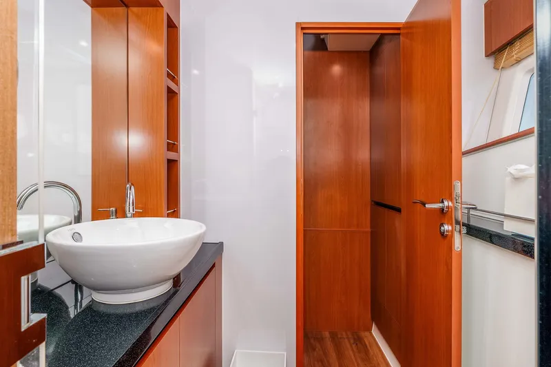 Catatude Yacht Photos Pics Luxurious bathroom interior of 2016 Aquila 44 Power Cat with modern sink and wooden cabinetry.