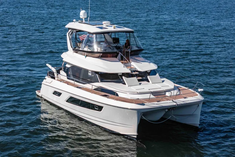 Catatude Yacht Photos Pics 2016 Aquila 44 Power Cat cruising on open water, showcasing sleek design and spacious deck.