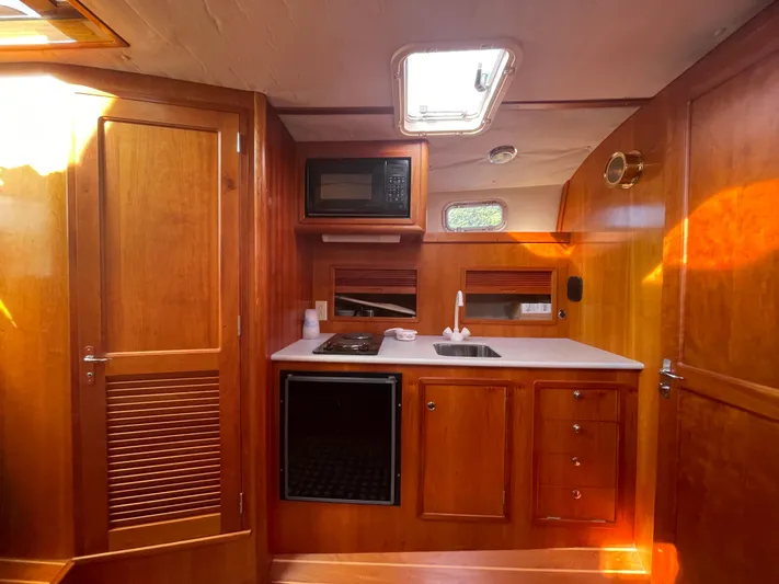  Yacht Photos Pics Interior of 1997 Little Harbor WhisperJet 36 yacht with wooden cabinetry and compact kitchen.