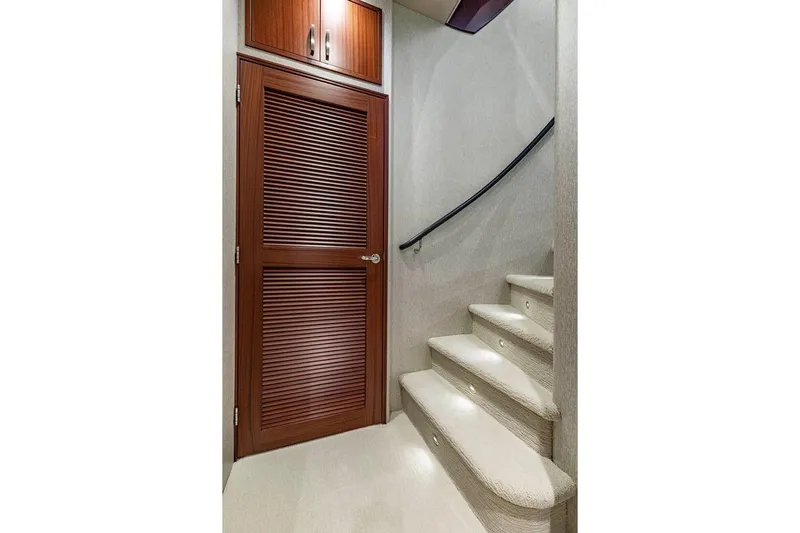  Yacht Photos Pics Interior staircase of 2014 Pacific Mariner 85 Motor Yacht with wooden door and carpeted steps.