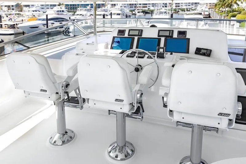  Yacht Photos Pics Helm station of 2014 Pacific Mariner 85 Motor Yacht with three white captain chairs.