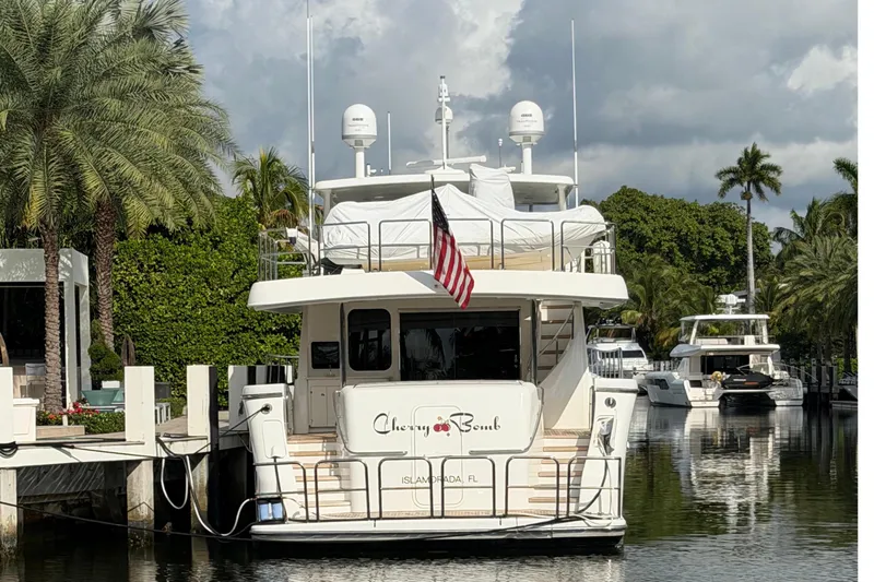  Yacht Photos Pics 2014 Pacific Mariner 85 Motor Yacht docked, surrounded by palm trees and calm water.