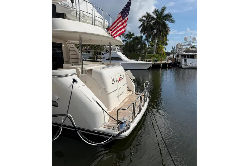  Yacht Photos Pics 2014 Pacific Mariner 85 Motor Yacht docked, featuring American flag and serene marina setting.