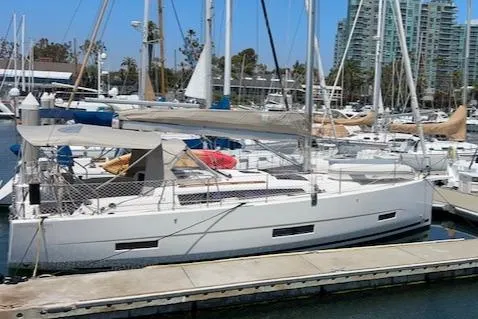 Gem Yacht Photos Pics 2022 Dufour 390 sailboat docked at a marina with other boats.