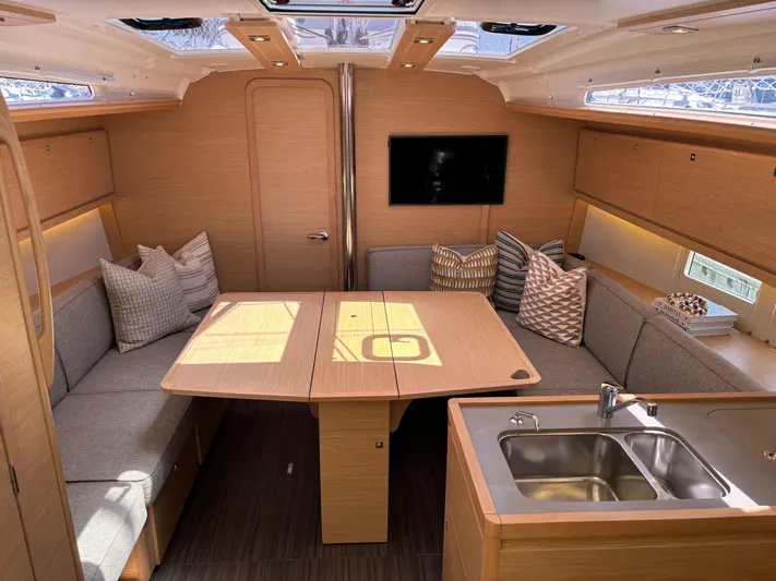 Gem Yacht Photos Pics Modern interior of 2022 Dufour 390 sailboat with cozy seating and kitchenette.
