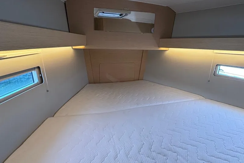 Gem Yacht Photos Pics Spacious cabin interior of 2022 Dufour 390 yacht with cozy bedding and ambient lighting.