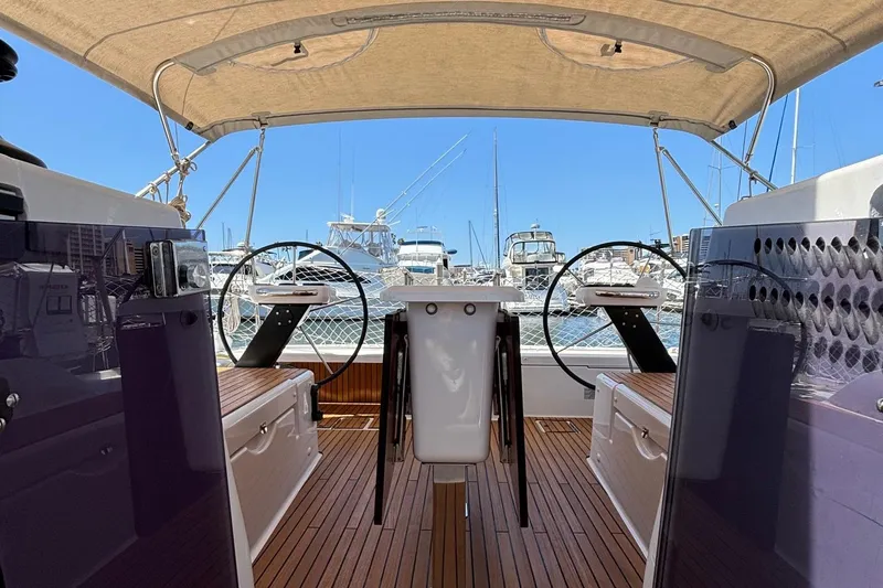 Gem Yacht Photos Pics Dufour 390 2022 model yacht cockpit with dual steering wheels and marina view.