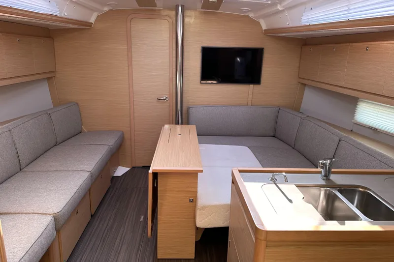 Gem Yacht Photos Pics Modern interior of 2022 Dufour 390 yacht with cozy seating and kitchenette.