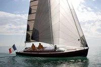 2023 Tofinou 9.7 sailboat on calm sea with French flag, sunny day.