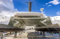 2018 Tag 60 catamaran on dry dock, showcasing hull design and structure under a blue sky.