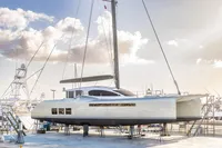 Luxury Tag 60 catamaran from 2018 on dry dock under a cloudy sky.