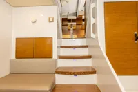 Interior of 2018 Tag 60 yacht with wooden stairs and seating area.