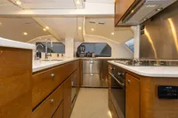 Luxurious yacht kitchen interior with modern appliances, wood cabinetry, and sleek design, Tag 60 model, 2018.